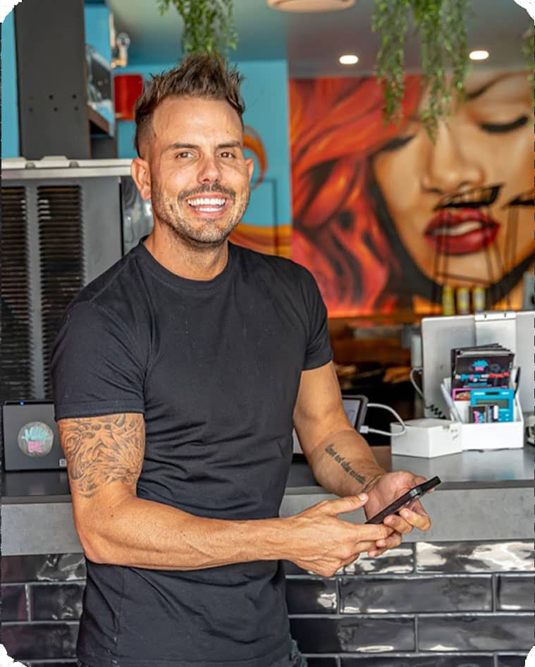 Man smiling in front of the camera in a Milky Lane restaurant bar